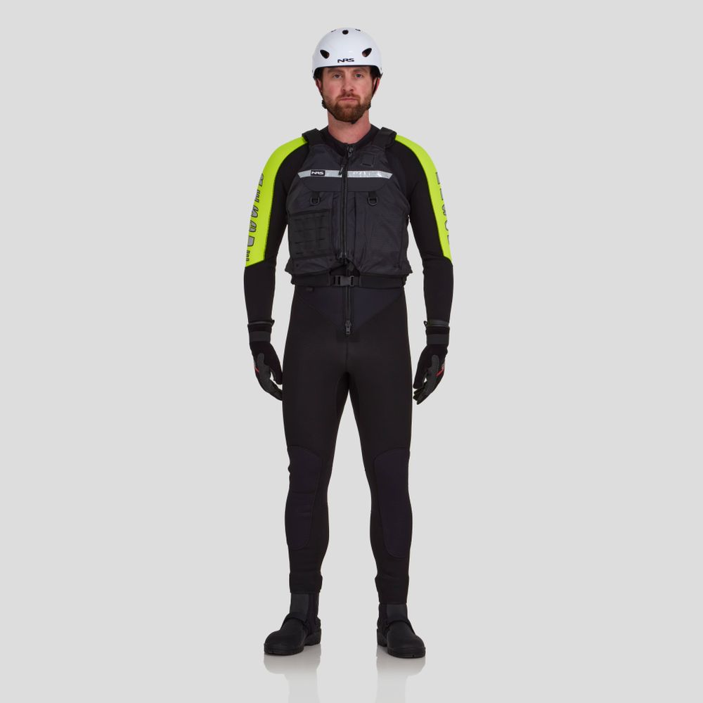 A person wearing an NRS Big Water Guide Hi-Float, a white helmet, and a black wetsuit with neon yellow sleeves and reflective tape stands against a plain background.