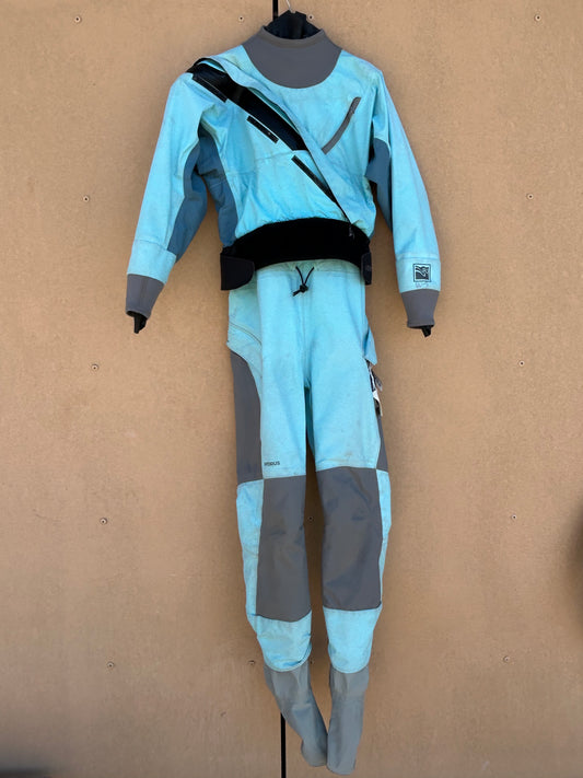 A full-body, light blue Kokatat Hydrus W's SM drysuit with grey accents is hanging on display against a plain background. The suit, suitable for rental use, features a zipper running diagonally across the chest and patches on the knees.