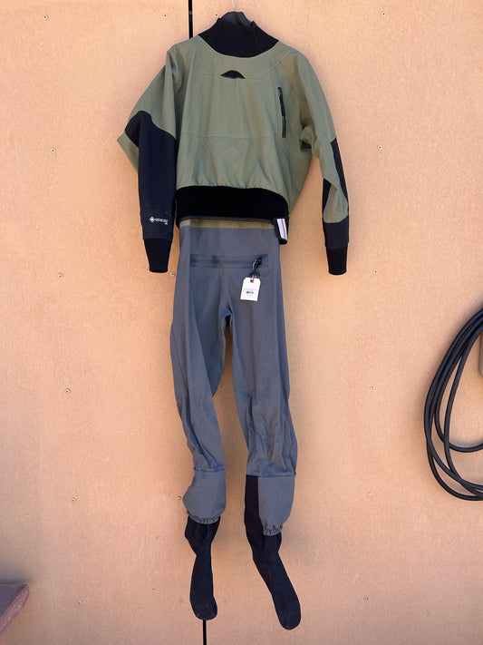 A Demo Drysuit - NRS Phenom Men's LG by NRS in black and green hangs on a wall, showcasing attached socks and a front zipper with a tag.