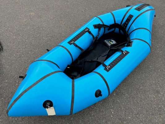 A Demo Gnarwhal raft sitting on the side of the road. Brand: Alpacka