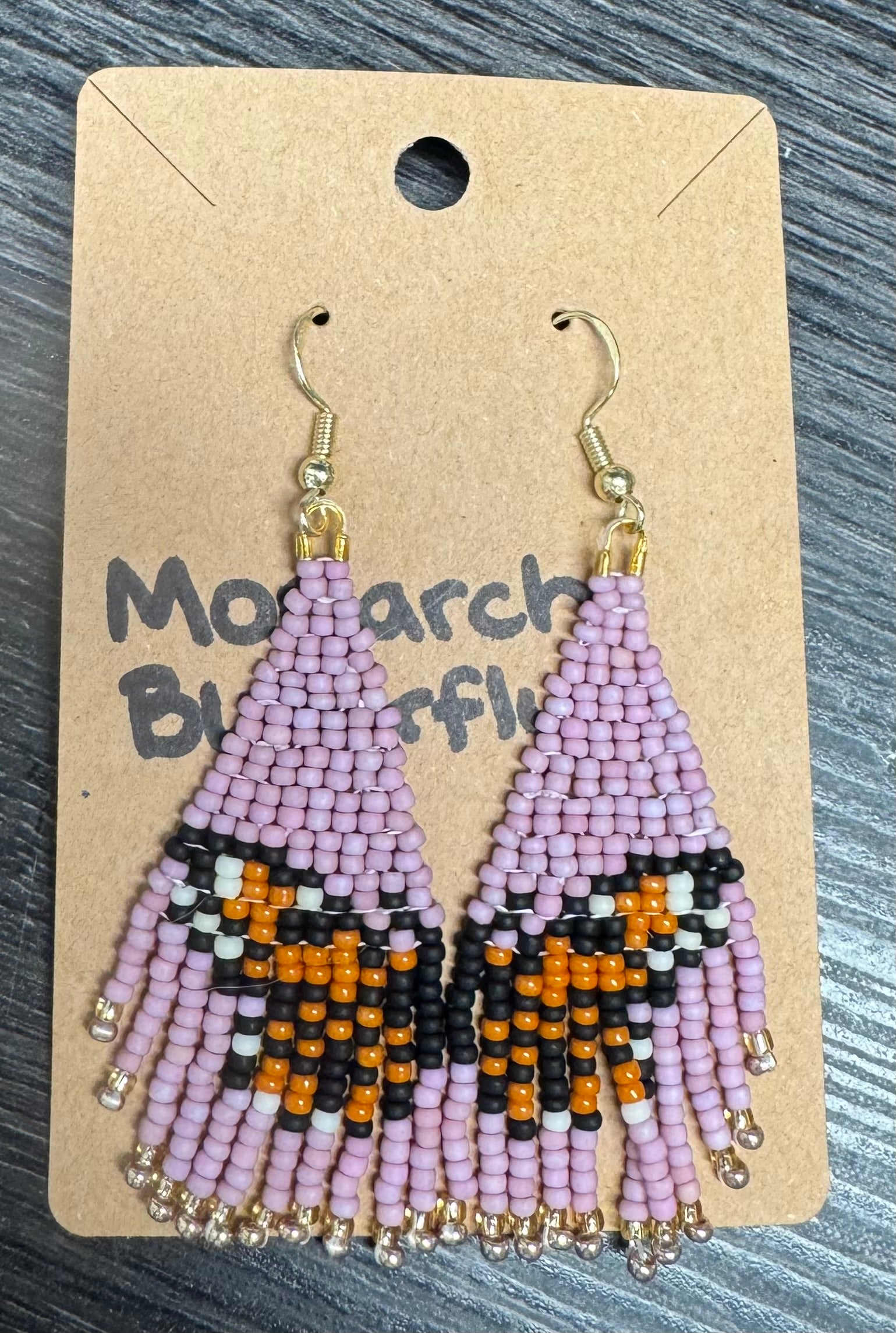 These Cutesy By Emilia Earrings by 4CRS are handcrafted to resemble monarch butterfly wings with pink, black, orange, and white beads. They come on a "Monarch Butterfly" card and beautifully capture desert flower designs.