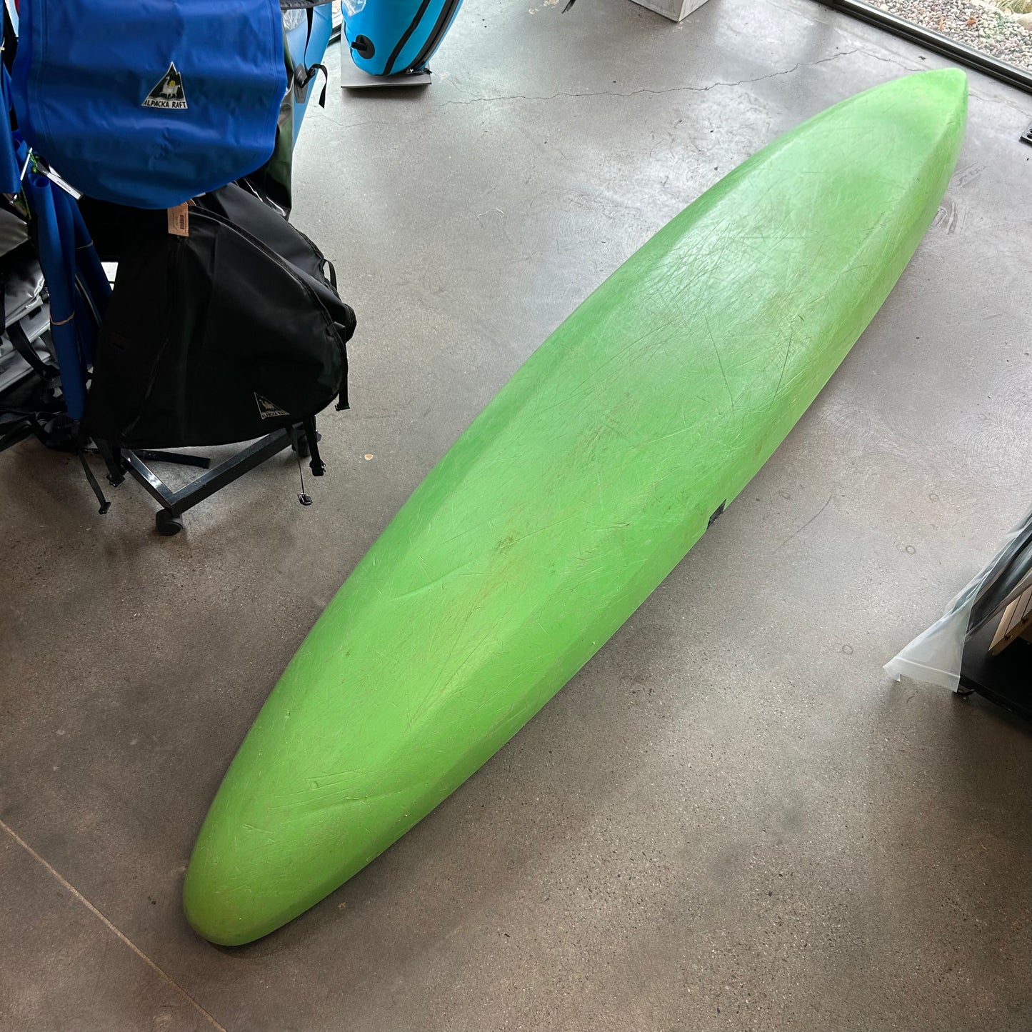 A Used Stinger by LiquidLogic in green sits on a concrete floor among recreational equipment, available for local pickup or consignment.