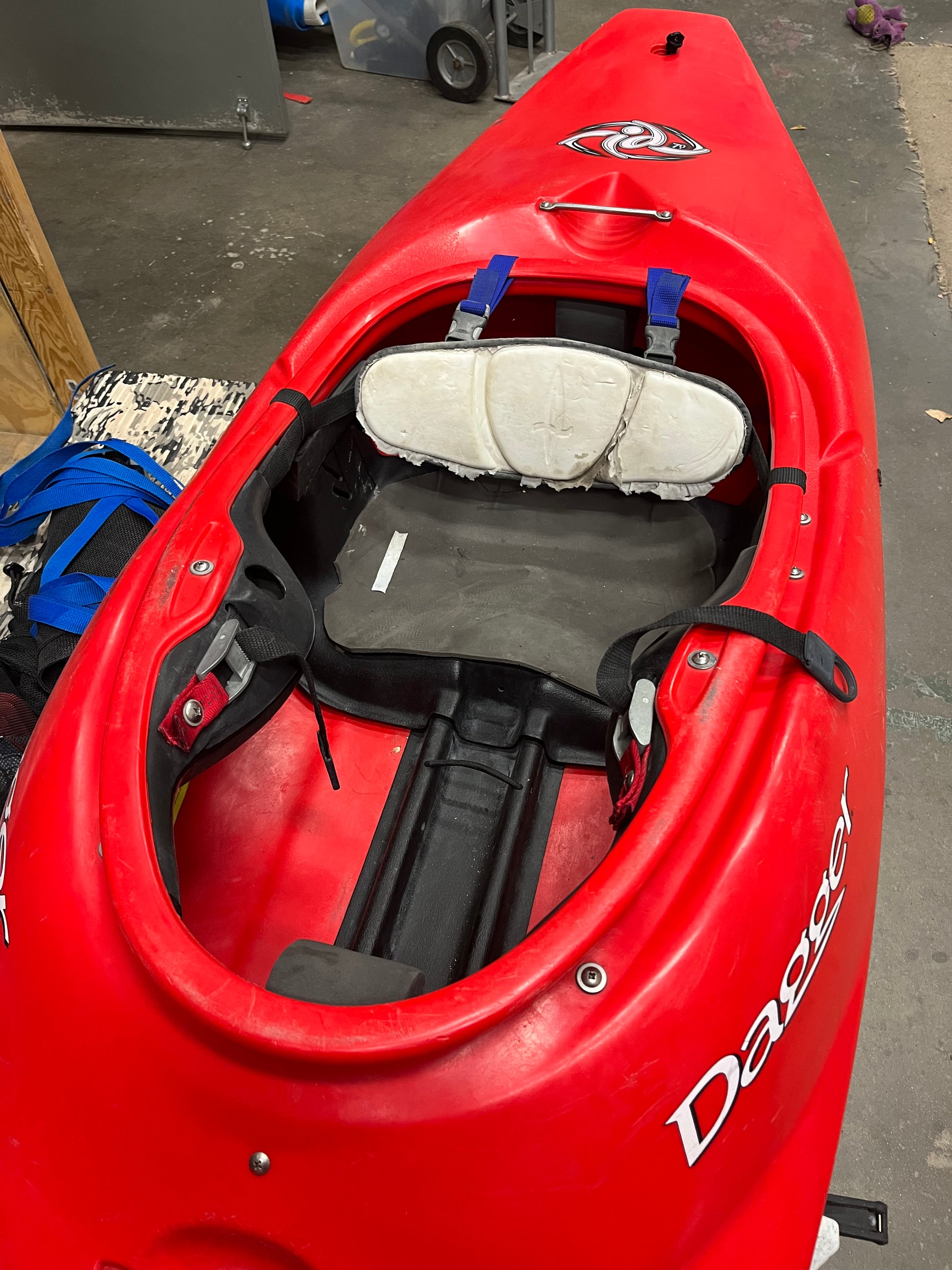 Consignment Dagger ID 7.0 red kayak with padded seat and footrests, stored indoors, branded "Dagger." It's in excellent condition for a smooth ride every time. Shipping costs not included.