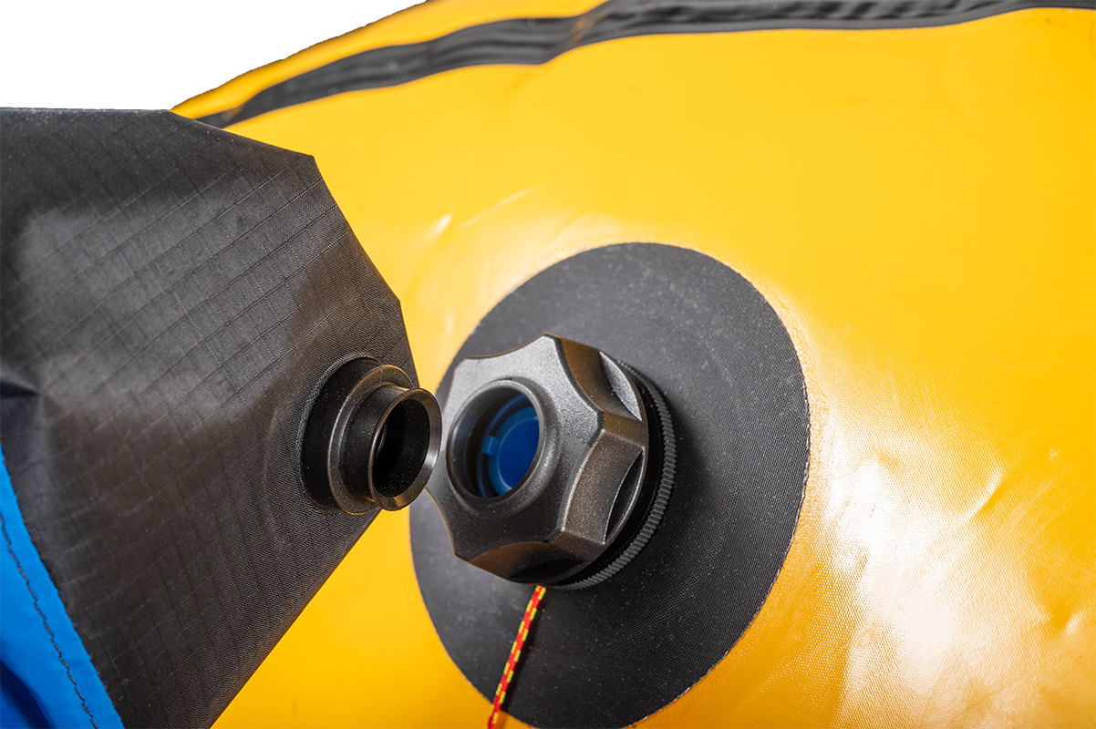 Close-up of a valve on a yellow inflatable device, with a black fitting being connected or disconnected using the Alpacka K-Pump Valve Adapter for Alpacka Rafts.