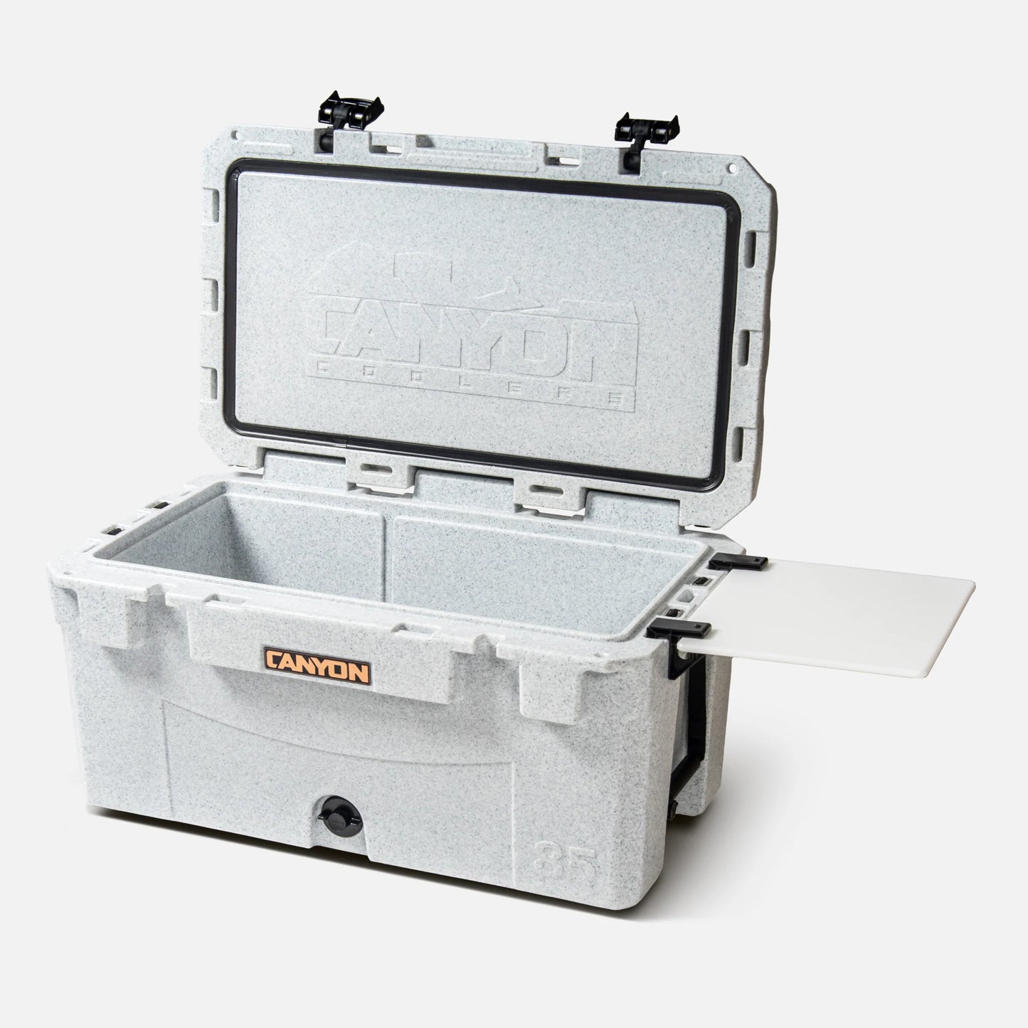 The PRO 85 Raft Cooler by Canyon Coolers is a gray insulated model with a cutting board attachment and excellent ice retention. With the lid open, it displays the word "Canyon" on its front.