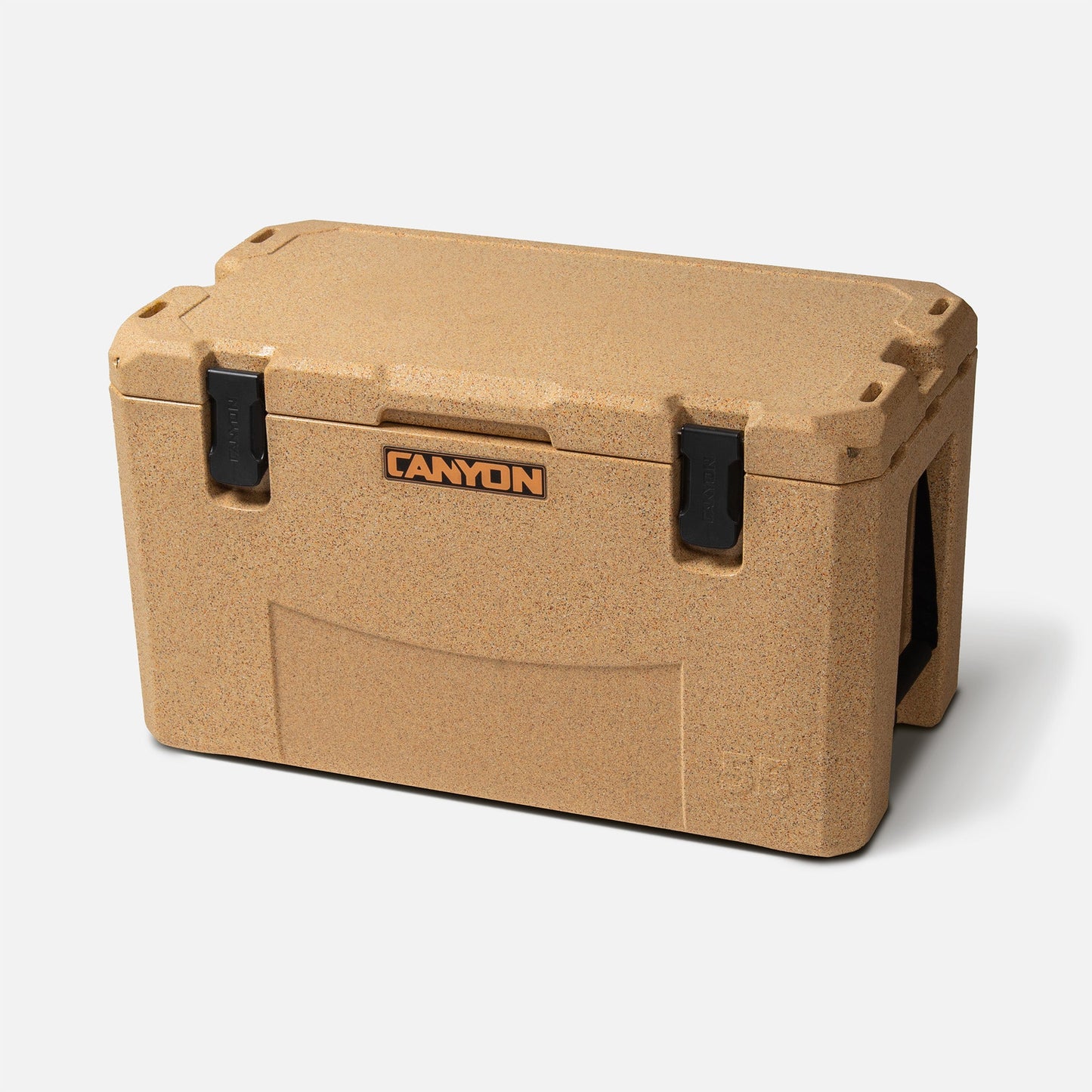 A tan rectangular insulated cooler from Canyon Coolers, known as the "Outfitter V2 Series," features an orange label, two black latches, premium seal, and dual action drain on the front.