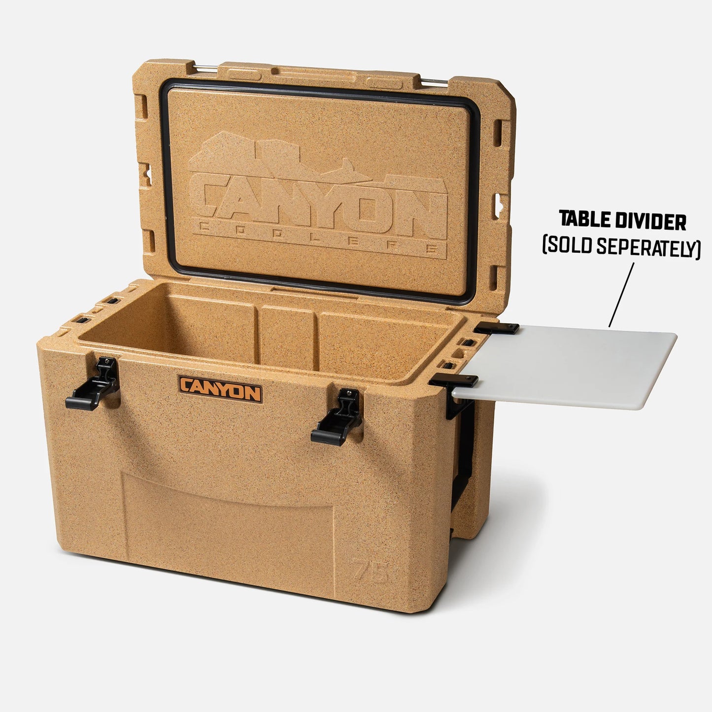 The tan Canyon Coolers Outfitter V2 features an open lid that reveals a spacious interior. Made from premium sun-resistant polymer, it is both durable and stylish. The table divider is sold separately, and the dual action drain ensures easy cleaning and maintenance.