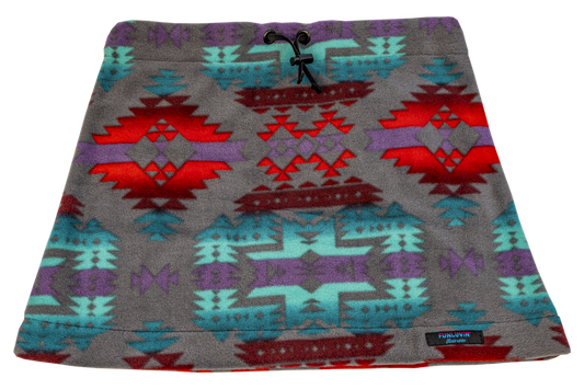 The FunLuvin' Fleece Skirt by FunLuvin' Fleecewear showcases a tribal geometric pattern in red, turquoise, and purple on a gray background. It features a comfortable elastic waistband and is crafted from anti-pill fleece for lasting wear.