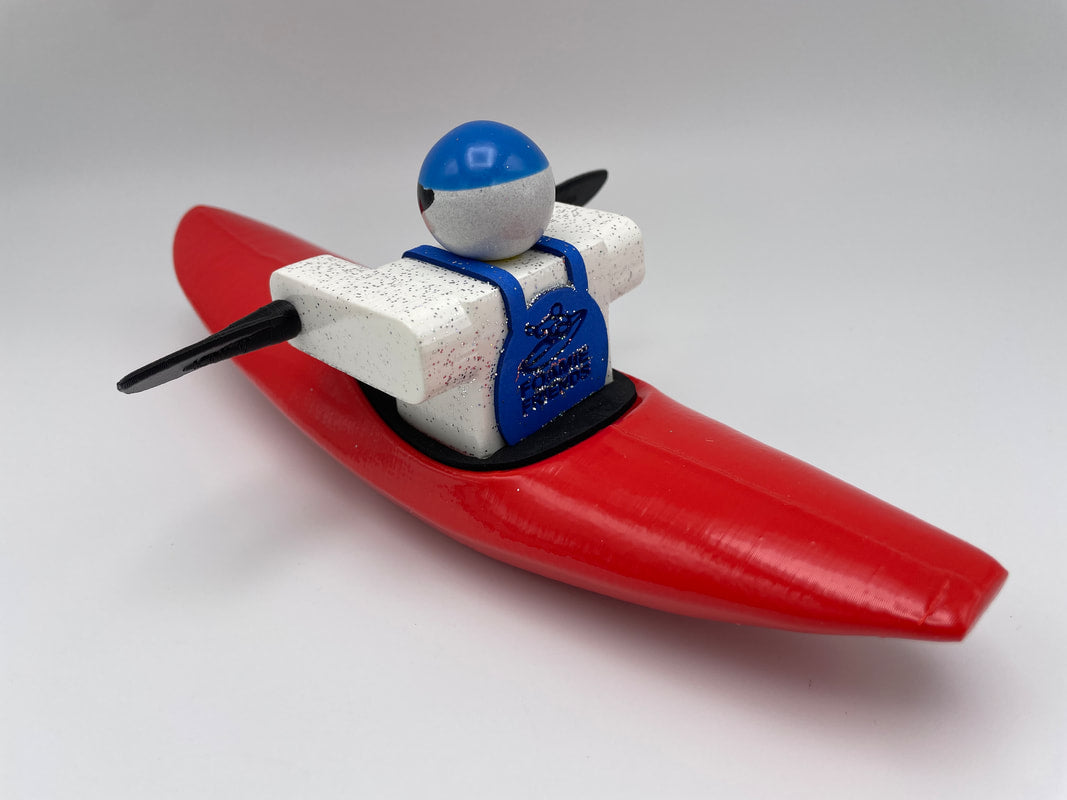 Foamie Friends presents the Foamie Creeker, a toy figure in a red kayak, wearing a blue helmet and vest, and paddling with black oars. Ideal for river play adventures against a white background.