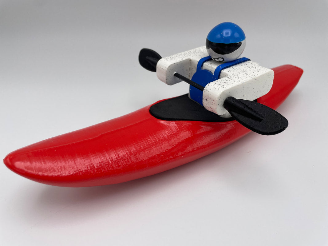 The Foamie Creeker from the Foamie Friends collection features a toy figurine donning a blue helmet, seated in a red kayak with black paddles against a white background, perfect for endless river play adventures.