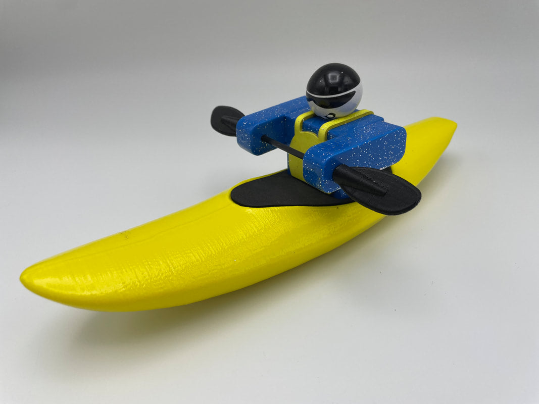 A Foamie Creeker from the Foamie Friends brand expertly maneuvers a yellow banana-shaped boat with bright blue paddles, capturing a playful river adventure against a simple backdrop.