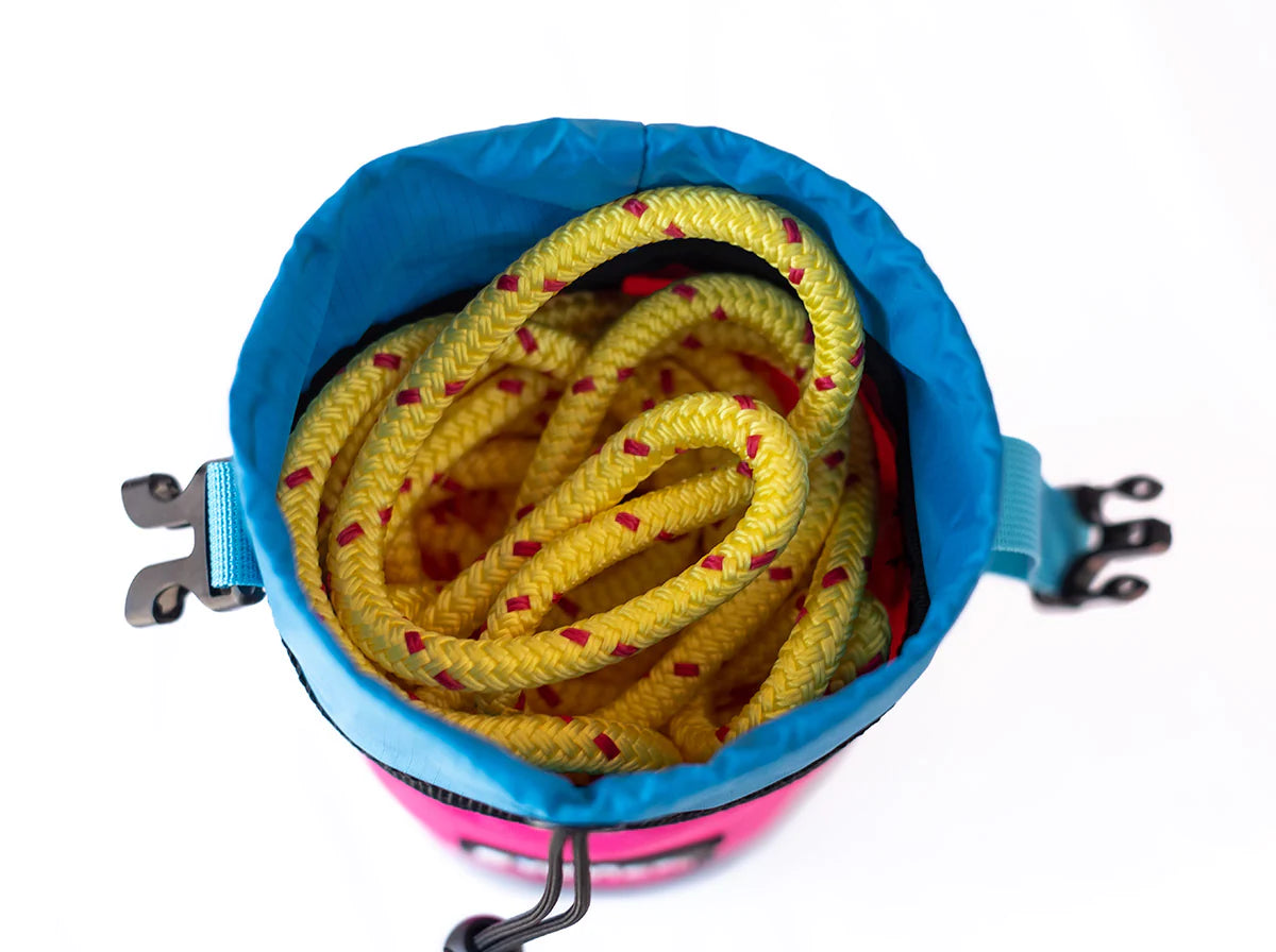 Climbing rope coiled inside a River Station Gear B.O.A.T. - Classic Rescue Throw Bag - 70ft on a white background.