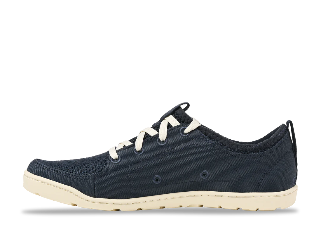 The Astral Loyak - Women's sneaker features navy blue hydrophobic canvas, white laces, and a beige sole, shown from the side on a plain white background.