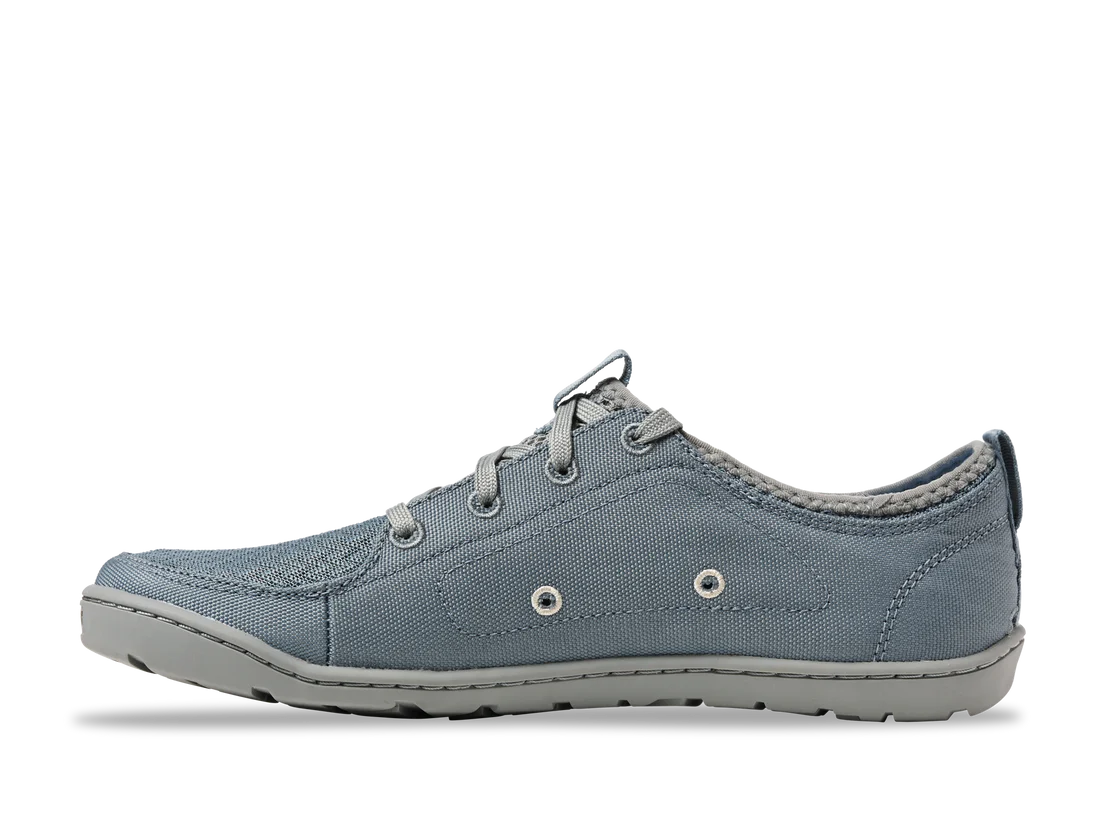 The Astral Loyak - Women's sneaker features a blue-gray canvas design with a textured FlexGrip sole, visible stitching, lace-up closure, and two decorative side eyelets, making it ideal for kayaking adventures.