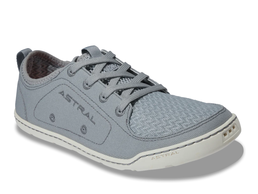 The Loyak women's sneaker by Astral features a gray, textured fabric upper with lace-up closure and a FlexGrip white rubber sole for traction. Perfect for kayaking, it seamlessly combines style and functionality with "Astral" on the side and sole.