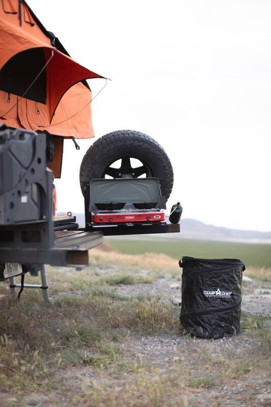 A camper trailer with a Camp Chef Collapsible Garbage Can-compliant camp kitchen on top of it.