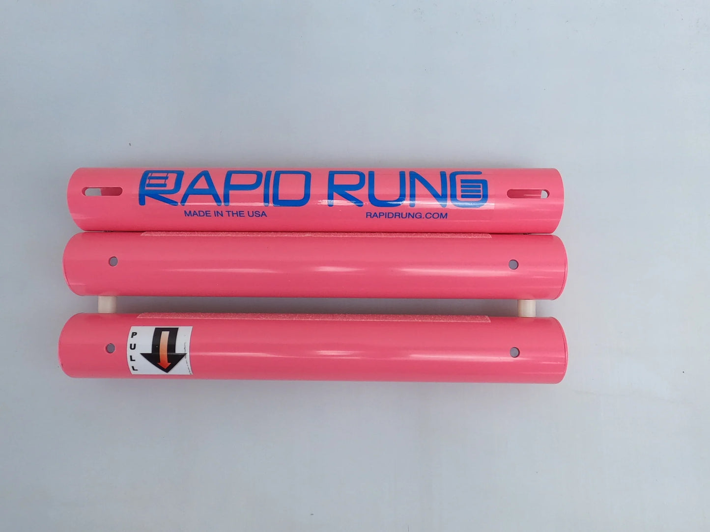 Image of three pink cylindrical objects placed parallel to each other. The top object displays the text "Rapid Rung Raft Ladder," while the bottom one features a "PULL" label accompanied by a downward arrow.