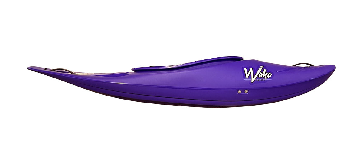 The Skuxx Deluxe by Waka Kayaks is a purple kayak ideal for versatile whitewater use, designed for down river freestyle adventures. It features the "Waka" logo on its side and is presented in a side view against a plain background.