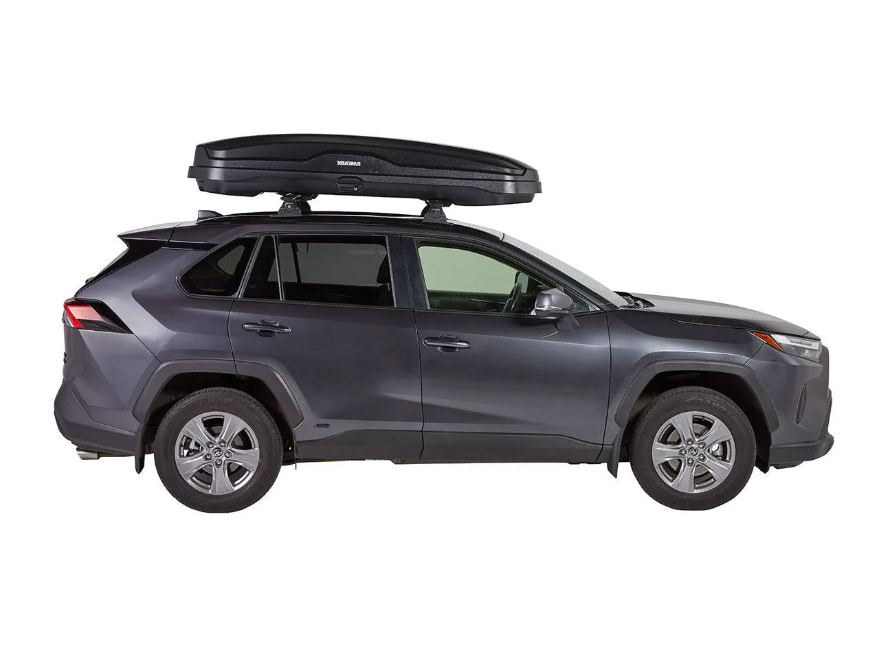 Gray SUV side view featuring a Yakima SkyBox NX Skinny rooftop cargo box against a plain white background. The sleek design provides ample storage and convenient tool-free installation.