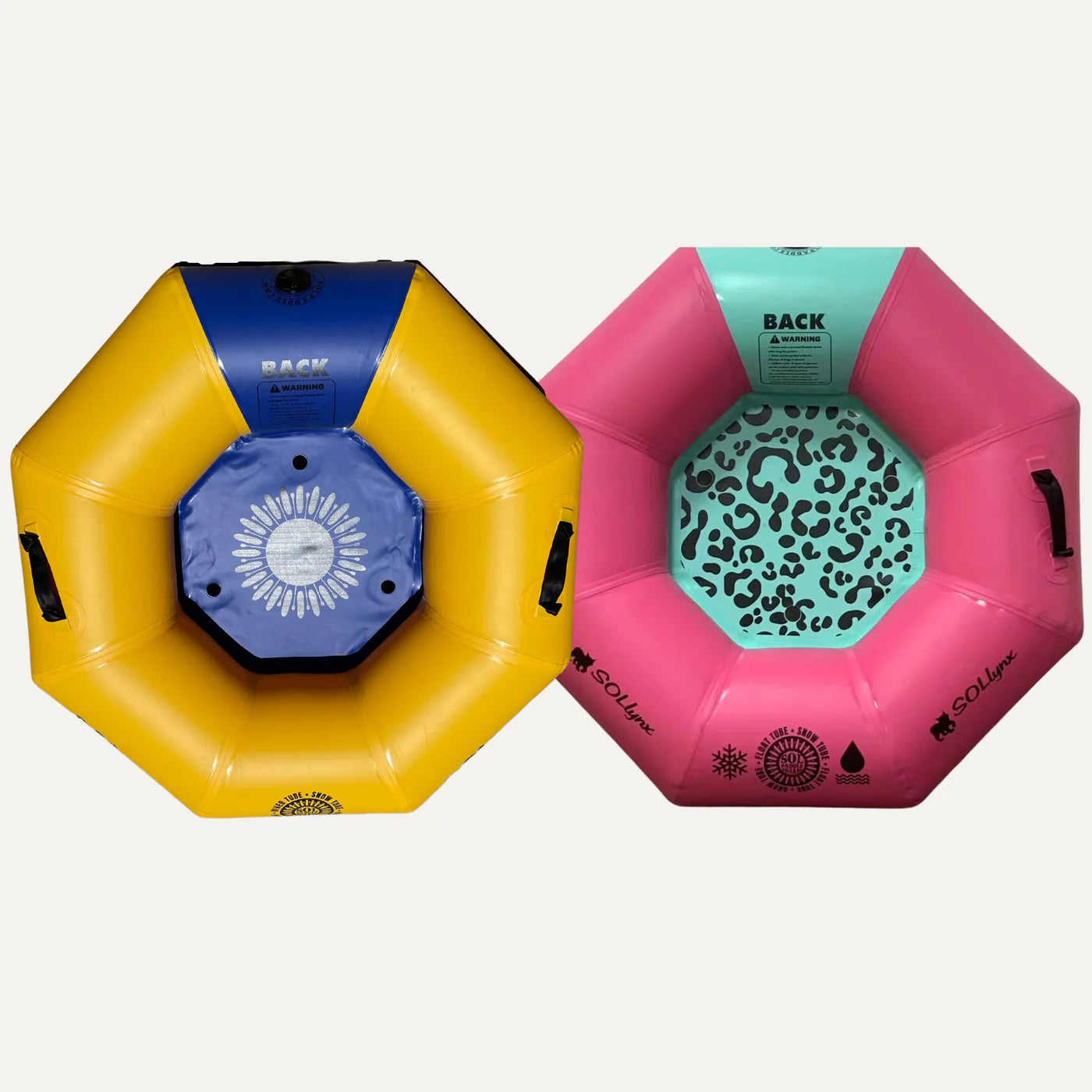 Two SOLtube inflatable snow tubes from SOL Paddle Boards, made with military-grade PVC, lie side by side. One is yellow and blue with a sun design; the other is pink and mint green with a leopard print. Both have handles and patterns, ensuring reinforced durability with welded seam technology.