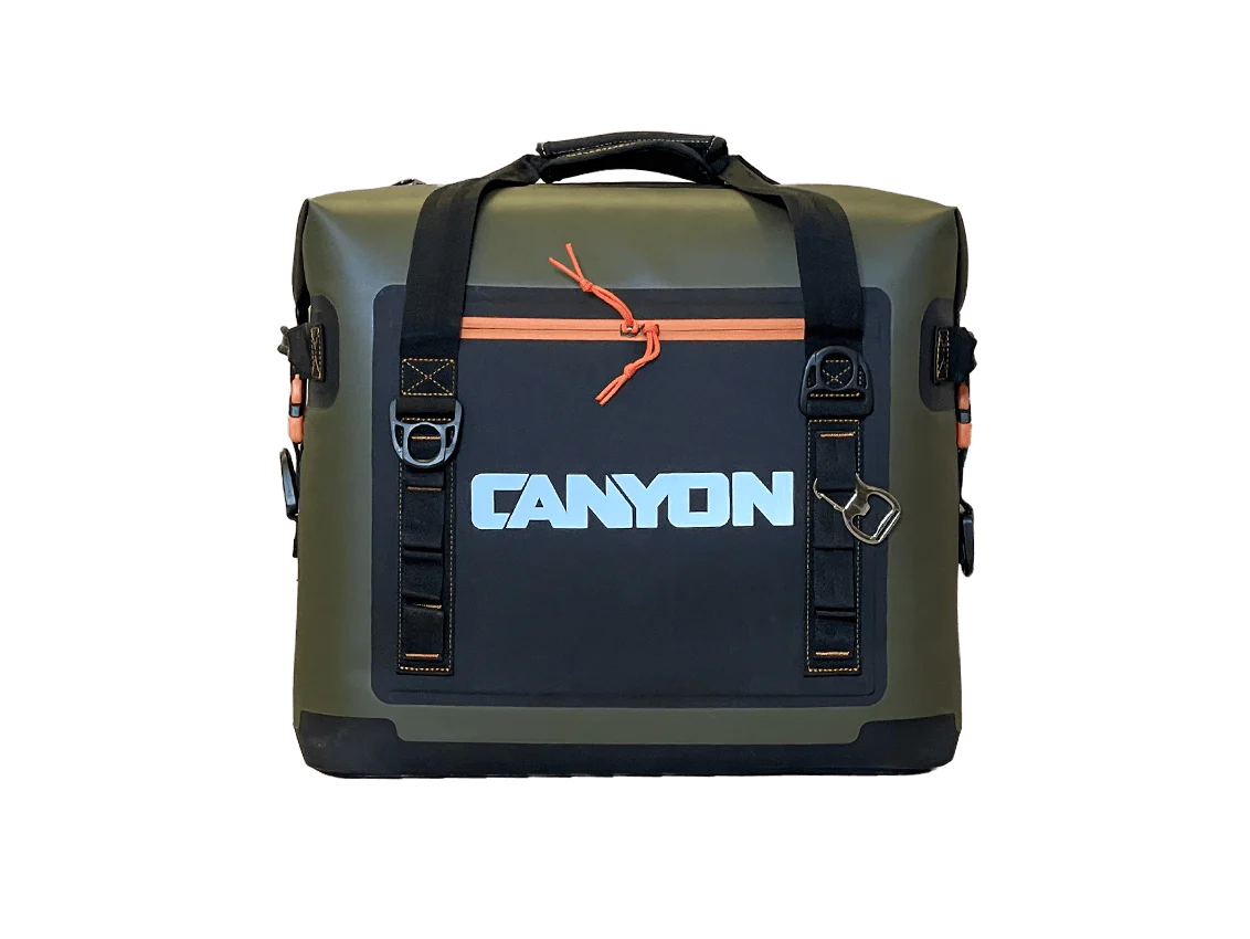 This durable olive-green and black soft cooler from Canyon Coolers' Nomad Series features a waterproof orange zipper, branded "CANYON" logo, multiple straps, a bottle opener attachment, and impressive ice retention for your adventures.